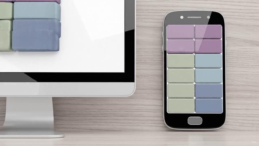 A desktop monitor and a phone side by side on a desk, showing the same grid of blocks reflowed to fit each screen.